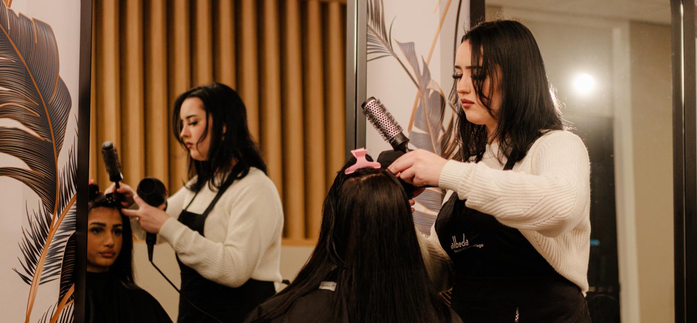 Studente haarverzorging knipt het haar van een klant