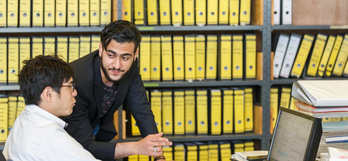 Kast met ordners en twee personen ervoor