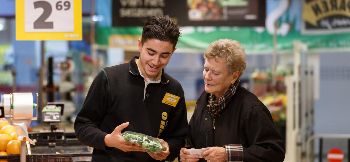 Man geeft vrouw advies in supermarkt