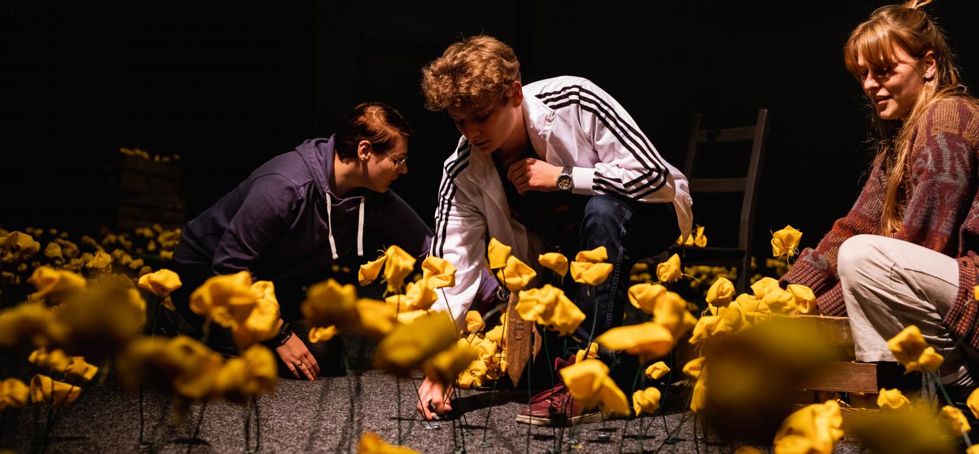 Theatervormgevers bekleden een podium met bloemen