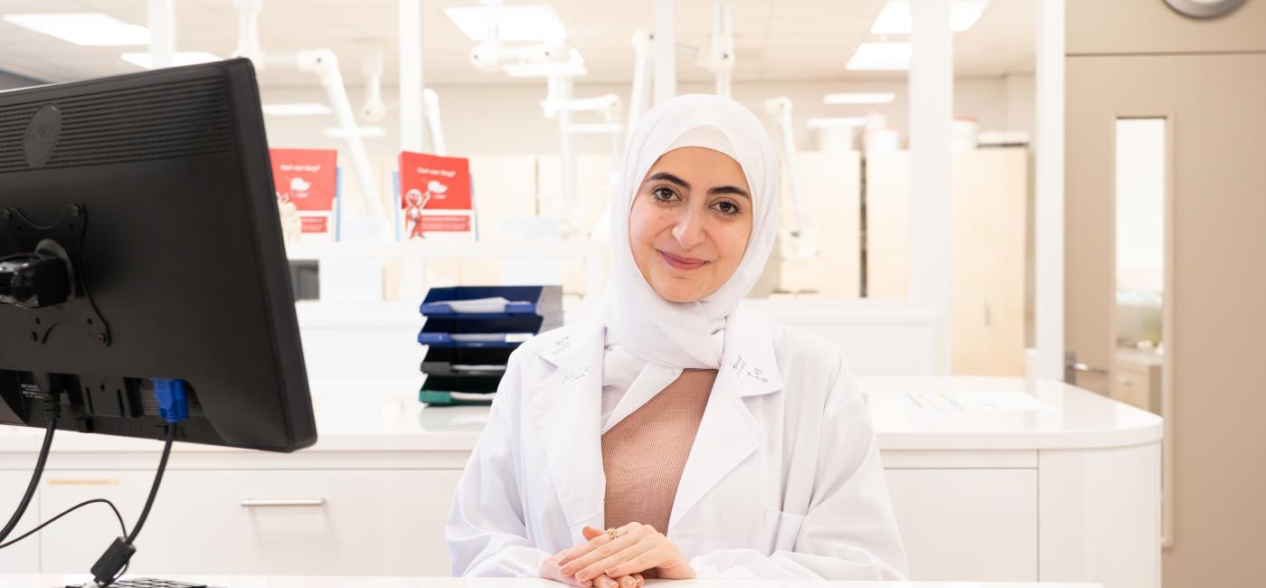 Assistent achter computer bij balie