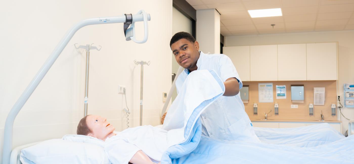 Verzorgende bij bed patient