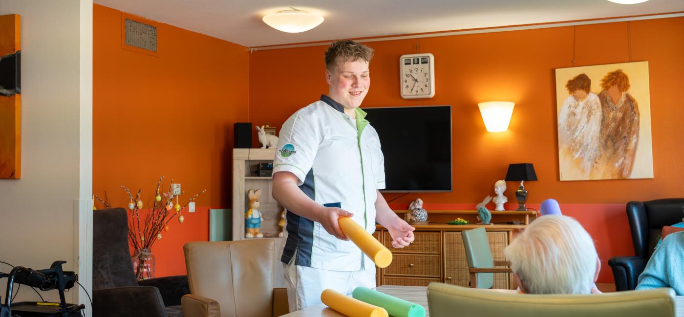 Verzorgende in woonkamer verzorgingshuis