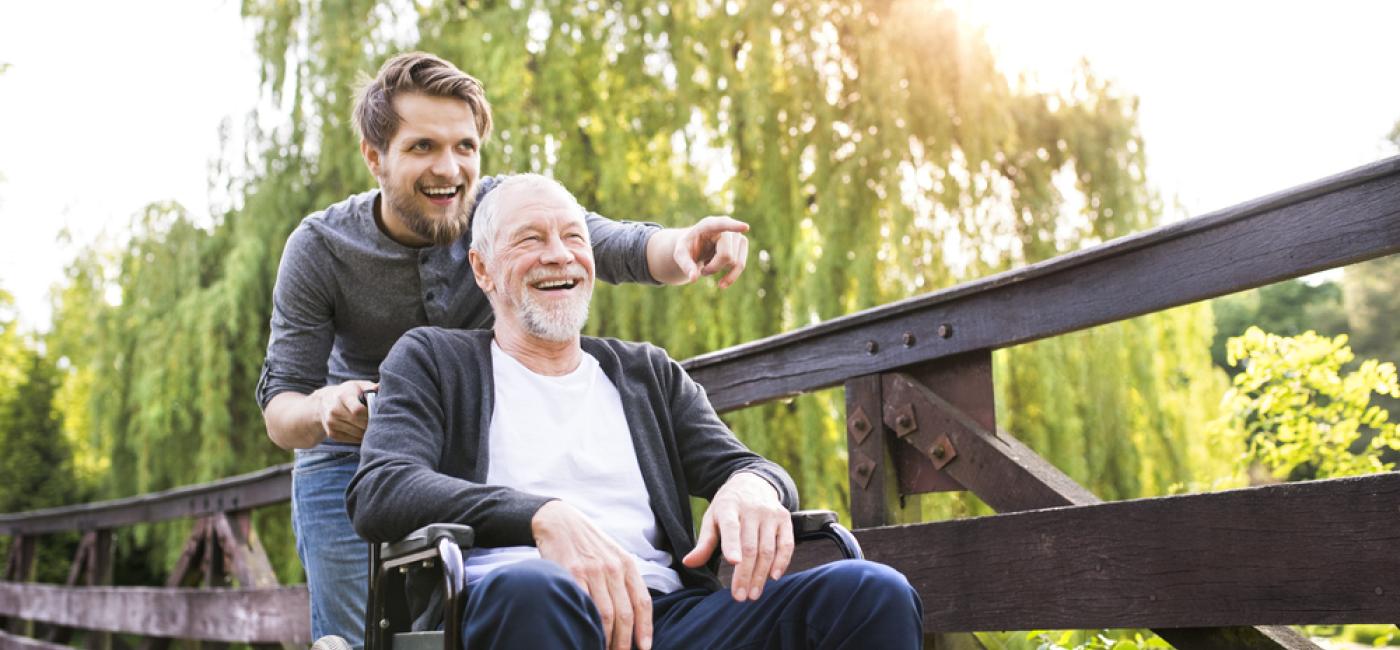 Wandelen met oudere man in rolstoel