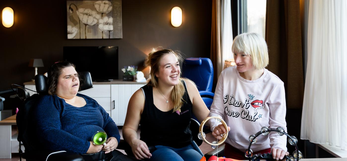 verzorgster met twee bewoners van een instelling